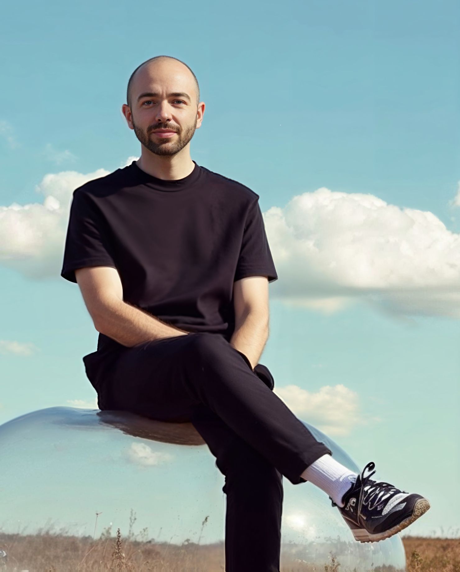 Das Bild zeigt einen Mann, der auf einer transparenten Blase in einer Wüstenlandschaft sitzt.